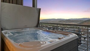 Un bain à remous sur un balcon avec vue sur les montagnes lointaines.