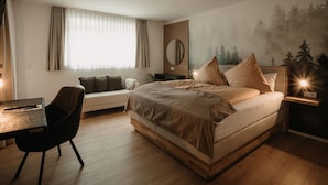 A modern bedroom with a large bed, a desk, and a chair.