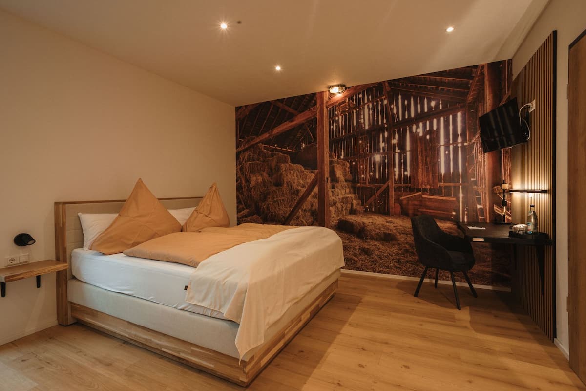 A bedroom with a bed, a desk, and a chair.