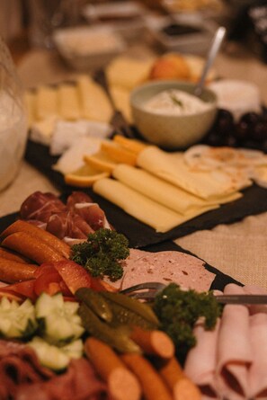 Une planche de charcuterie avec différentes sortes de viandes, de fromages et de légumes.