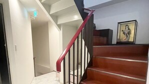 Eine Treppe mit roter Geländer und Holzboden, die zu einer Aussichtsplattform führt.