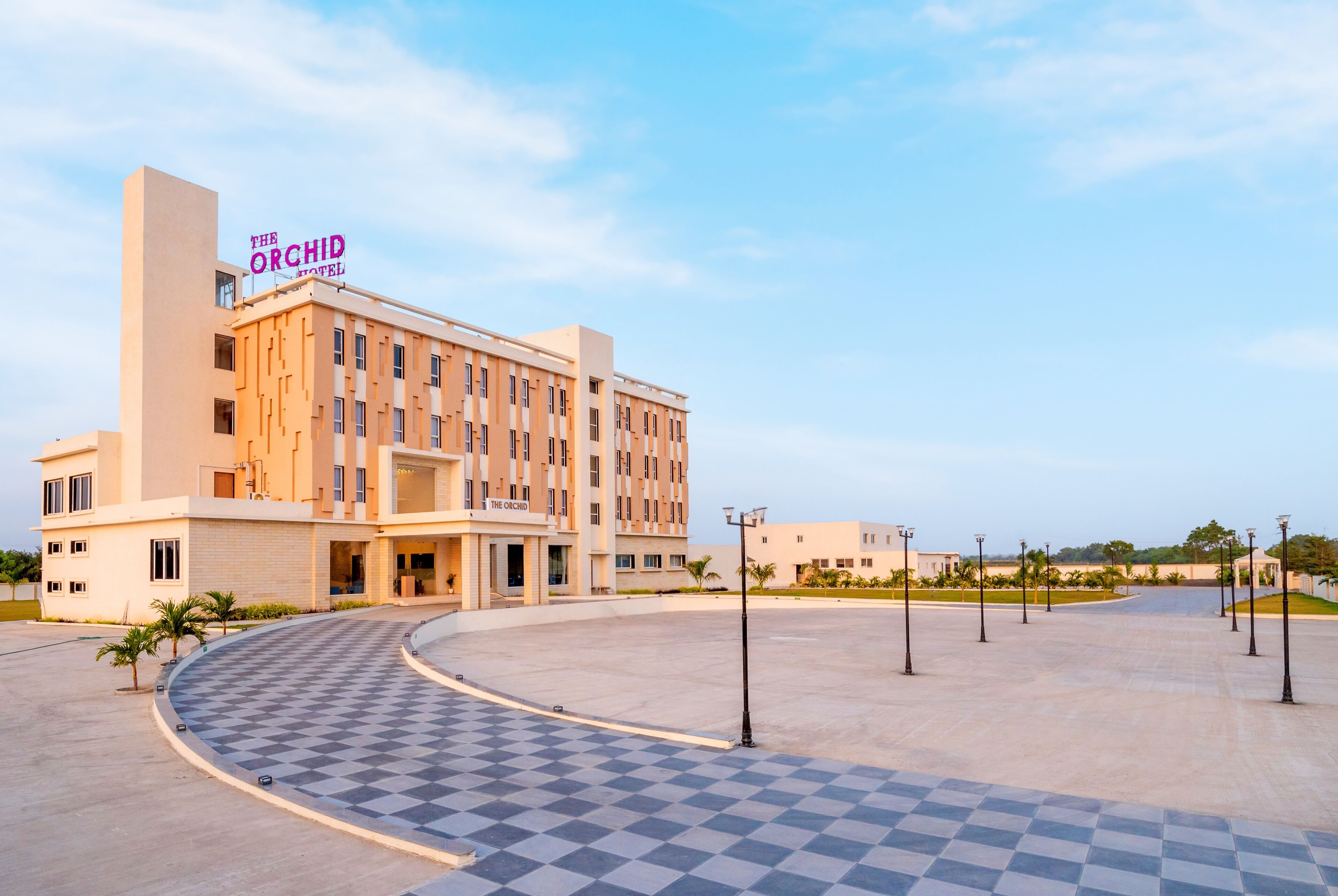 A hotel with a checkered entrance area and a sign reading "The Orchid Hotel".