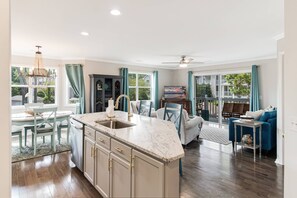 A spacious living area with a kitchen island, dining table, and seating. - Great Location in St James -  2 BR Villa with Pool (Southport)