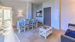 Un apartamento moderno con comedor, kitchenette y sala de estar.
