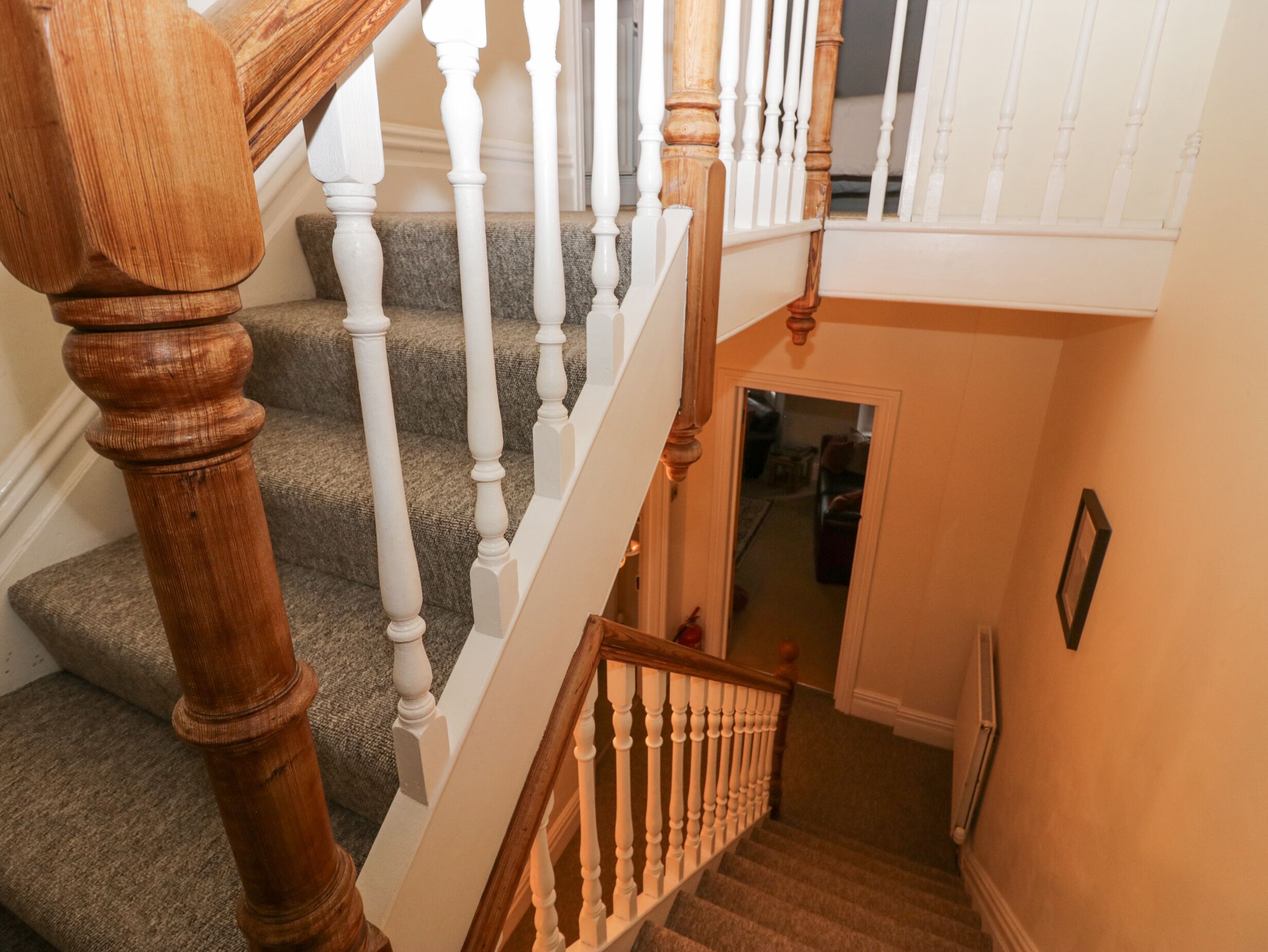 A staircase with wooden balusters and carpeted steps leading to an upper floor.