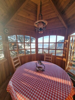 Enjoy meals at a large, round table with a scenic mountain view.