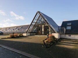 A modern building with a glass facade and a sloped roof.