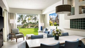 A modern hotel room with a dining area, a sofa, and a TV. - Westin Lagunamar Ocean Resort - Luxurious 1-Bedroom Villa - Family Friendly Resort! (Cancun)