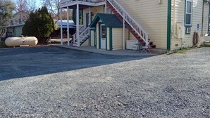 A two-story building with a covered porch, a staircase, and a small outdoor seating area. - All Season's Groveland Inn  (Groveland)