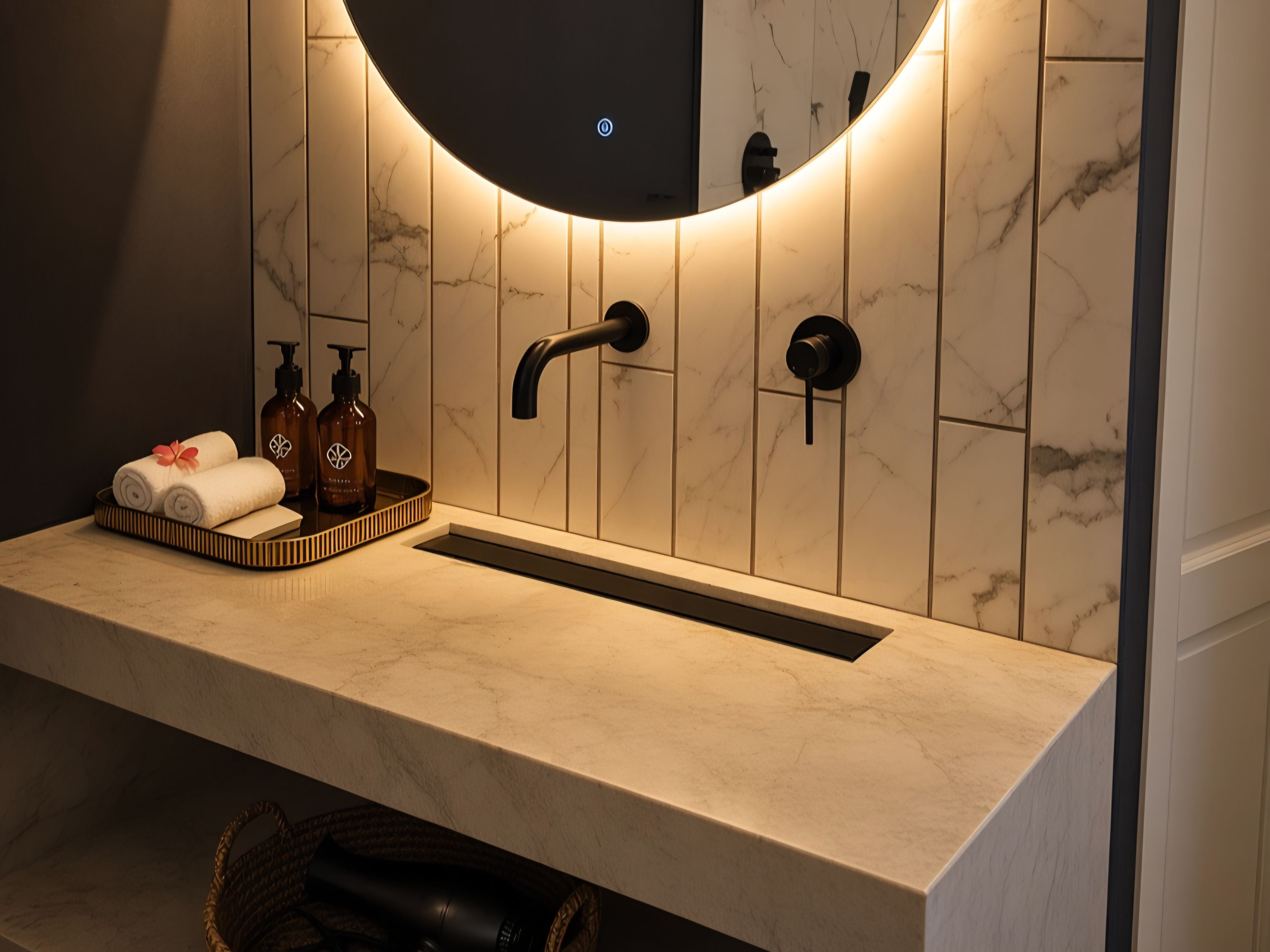 A bathroom with a marble sink, a round mirror, and a towel rack.