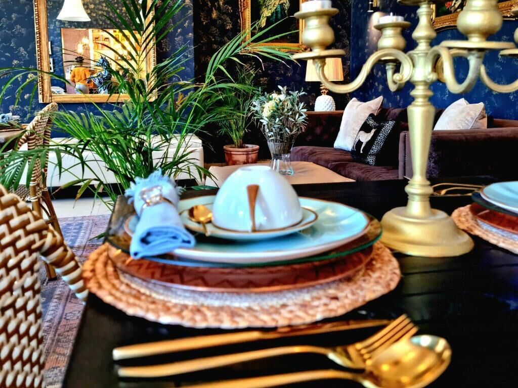A dining table set with plates, a vase of flowers, and a candelabra.