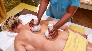 A person receiving a massage with two white massage rollers on their back.