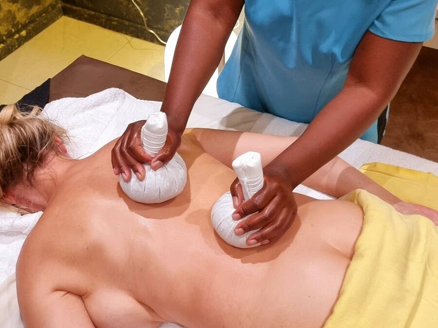 A person receiving a massage with two white massage rollers on their back.