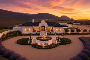 Une grande maison de plain-pied, dotée d’une pelouse bien entretenue, d’une fontaine et d’une allée menant à l’entrée.