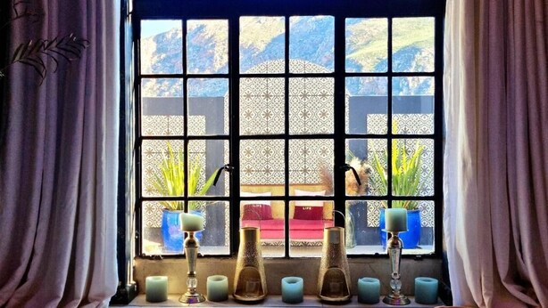 A spa area with a bathtub, candles, and a window with a view of a garden. - Maison Pjure Boutique Hotel & Spa ( Adults Only ) (Montagu)