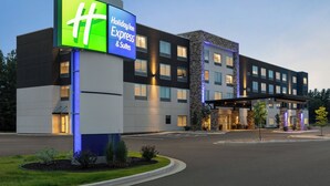A Holiday Inn Express & Suites hotel with a modern design, featuring a prominent illuminated sign, a covered entrance, and a landscaped driveway. - Holiday Inn Express and Suites Rhinelander by IHG (Rhinelander)