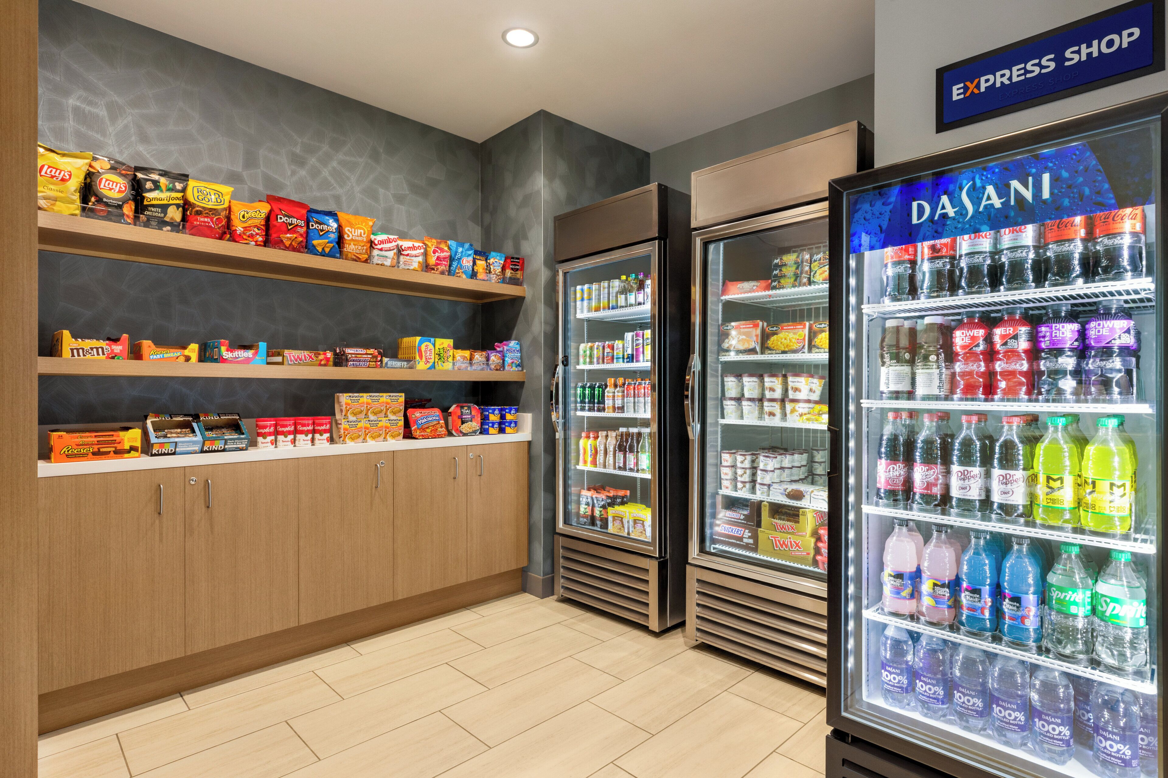 A snack and beverage section with shelves of chips, a refrigerated display of drinks, and a sign for the express shop.