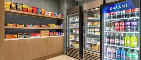A snack and beverage section with shelves of chips, a refrigerated display of drinks, and a sign for the express shop.
