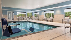 A pool area with a lifeguard chair, lounge chairs, and a view of the outdoors. - Holiday Inn Express and Suites Rhinelander by IHG (Rhinelander)