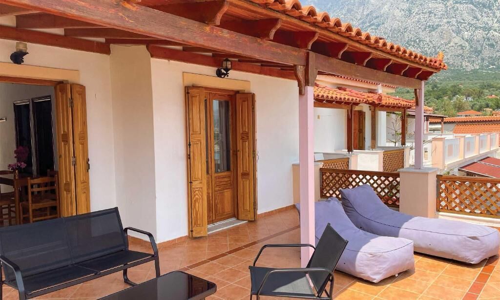 A covered outdoor area with wooden doors, a bench, and a lounge chair.