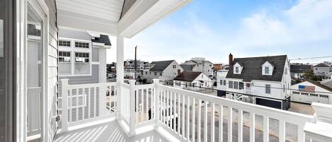 A white balcony with a view of neighboring houses.