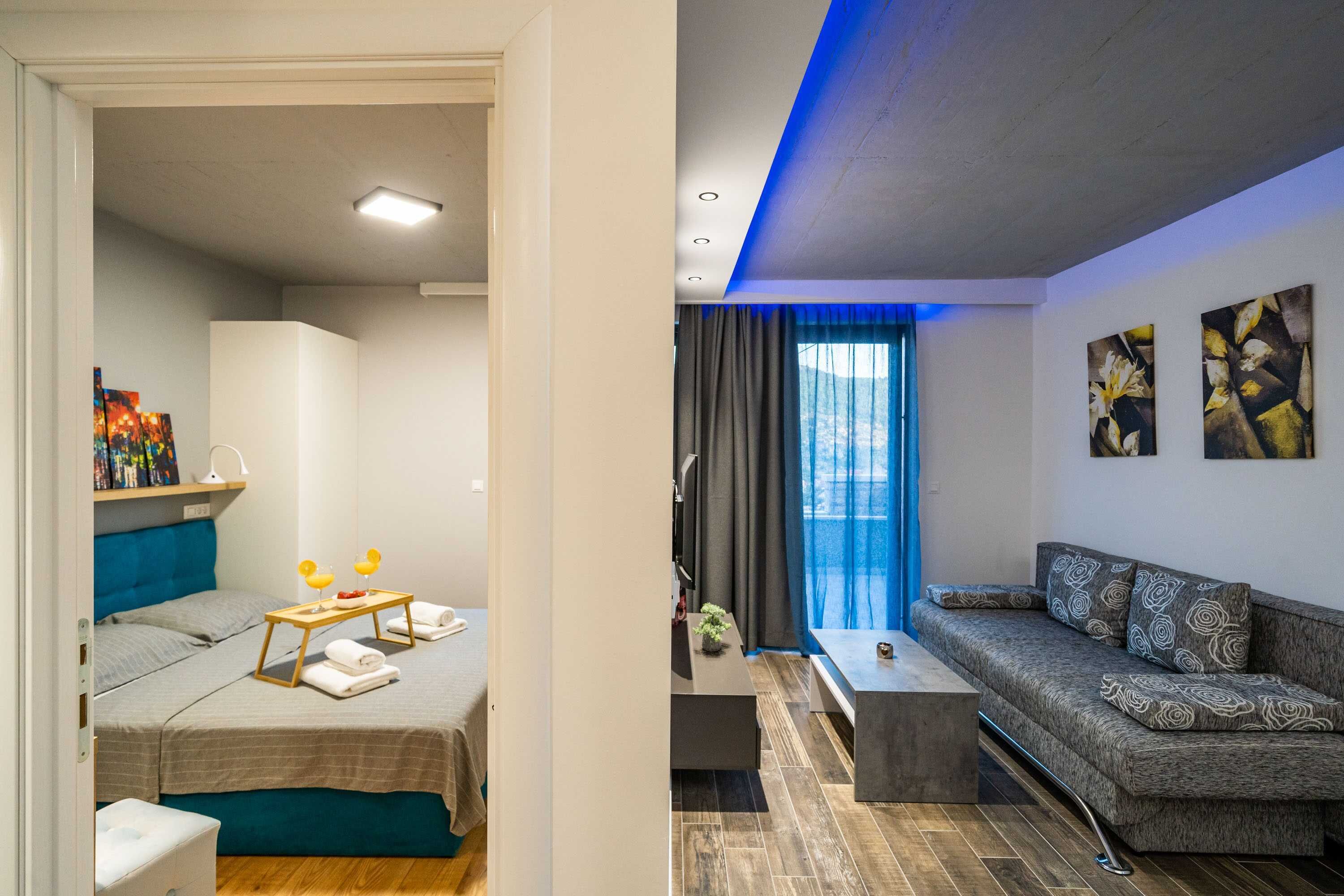 A modern hotel room with a bed, bedside table, and a sofa.