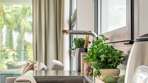 A modern kitchen with a stainless steel countertop, a sink, and a potted plant. - Sanders Evolution 2 Lovely 2 Bedroom Apartment With Balcony (Limassol)