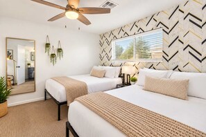 A hotel room with two beds, a ceiling fan, a large mirror, and a geometric patterned wall. - Vacay on Villa | Old Town |Swim, Putt, Play & Stay (Scottsdale)