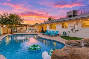 A swimming pool with lounge chairs and a building with outdoor lighting. - Vacay on Villa | Old Town |Swim, Putt, Play & Stay (Scottsdale)