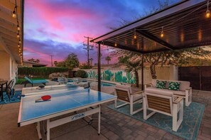 An outdoor ping pong table, seating area, and a cactus mural under a covered patio. - Vacay on Villa|Pool + Putting Grn|Old Town (Scottsdale)