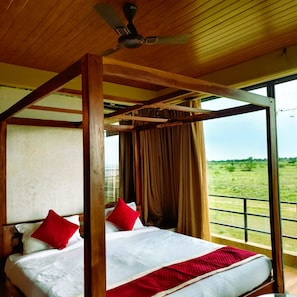 A room with a bed, a ceiling fan, and a view of the outdoors. - Camp Sambhar (Phulera)