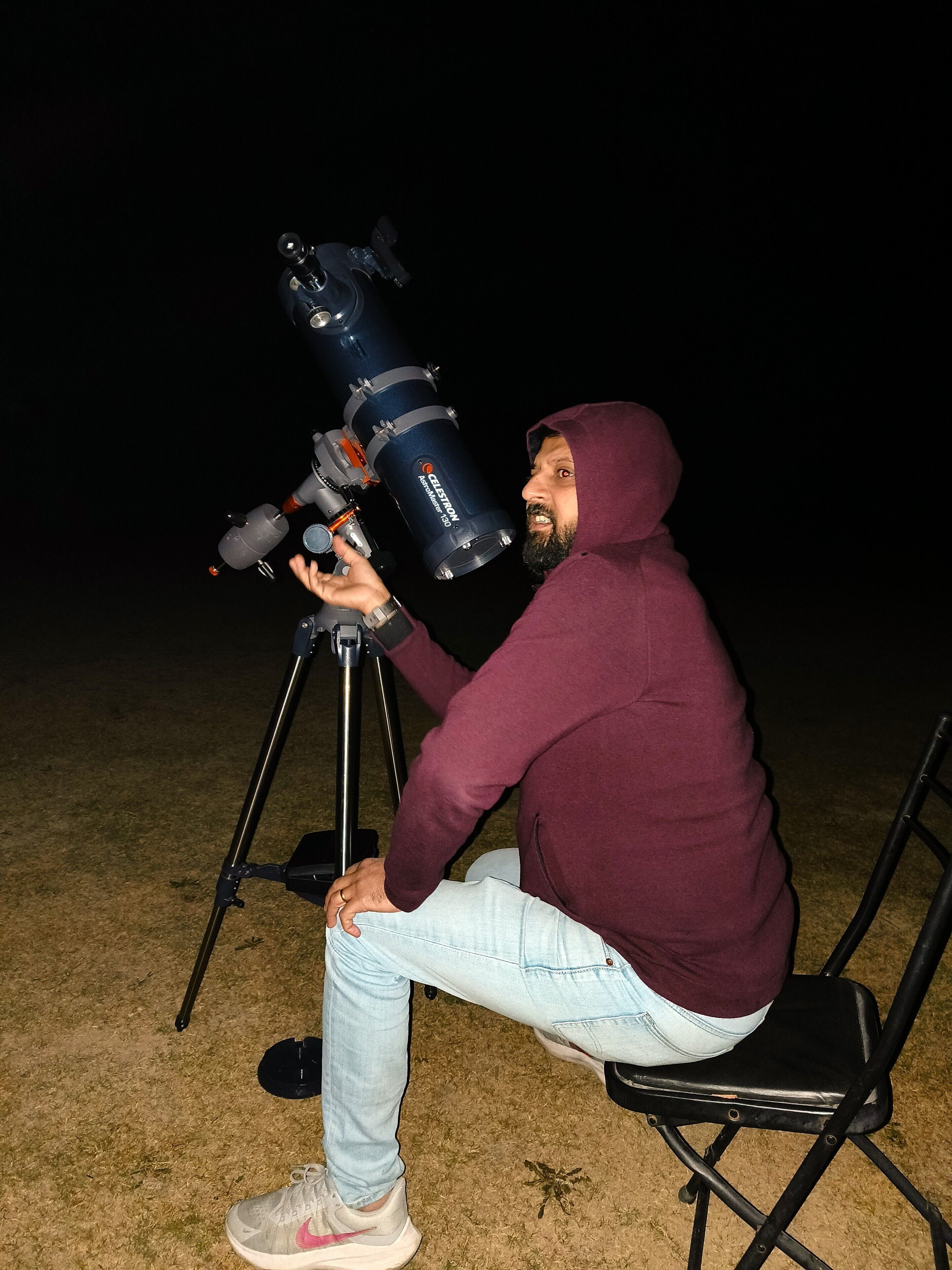 A person using a large telescope on a tripod.