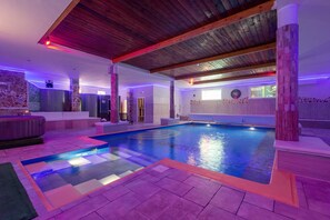 A swimming pool with a wooden ceiling and stone walls, surrounded by a tiled deck. - 3664 Resort Re Sole - App. Michelle (Grottaglie)