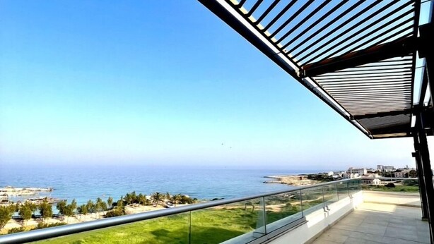 A balcony with a clear view of the sea and a distant shoreline. - Emerald Bay Suites (Paralimni)