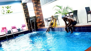 An indoor swimming pool with a brick wall and a tiled floor. - GRACIAS HOTEL AND SUITES (Lekki)