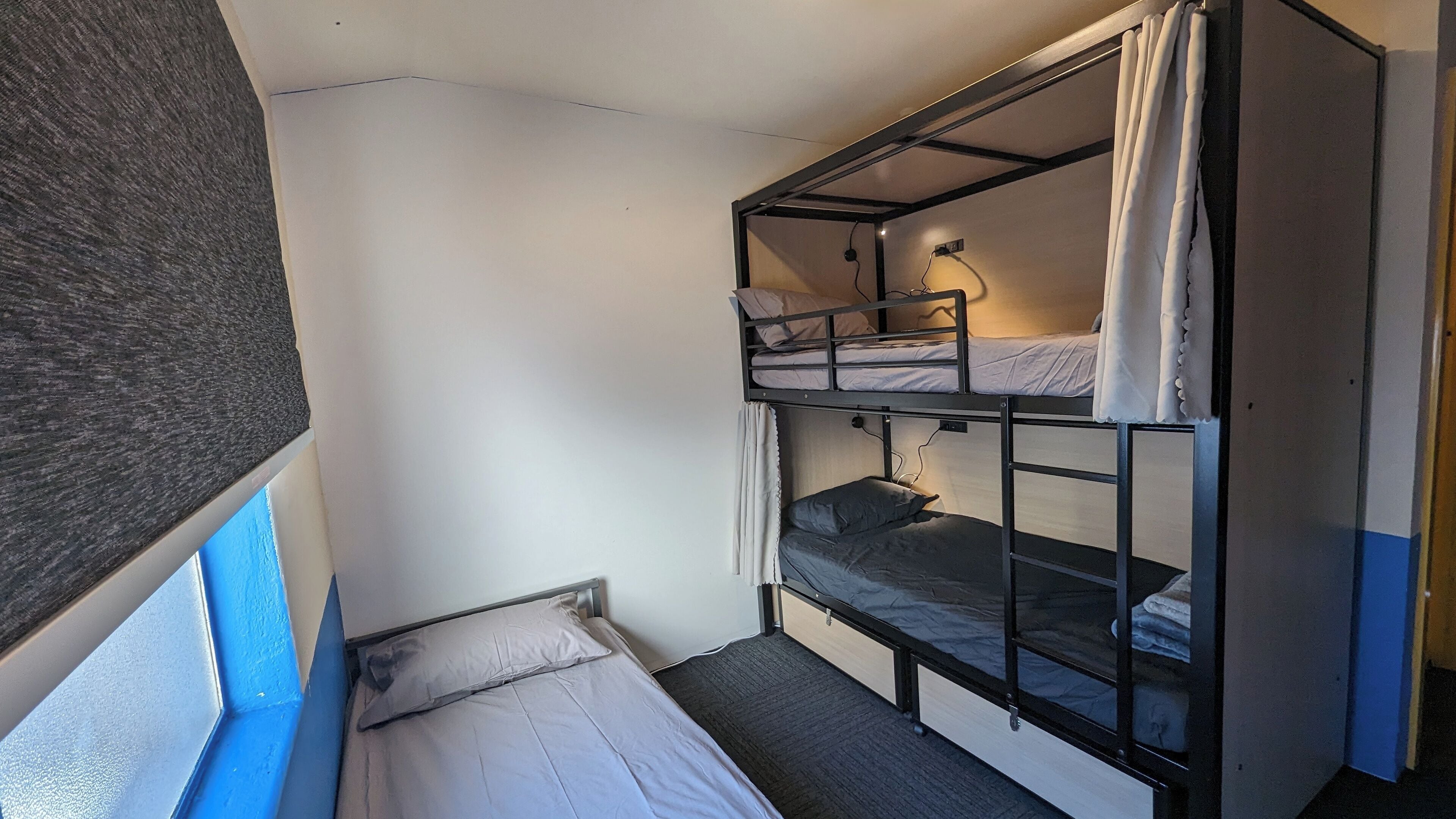 Une chambre avec un lit superposé, un bureau et une lampe.