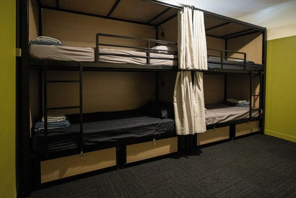 Une chambre avec un lit superposé à deux niveaux, chaque niveau étant équipé d’un matelas et d’un oreiller.