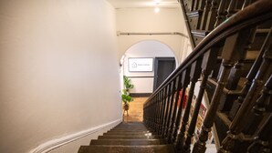 A wooden staircase with a handrail, leading to a room with a sign reading "Base Camp."