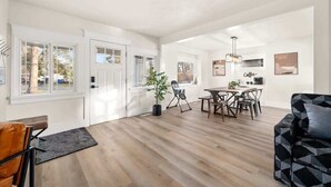 A spacious living area with a dining table, chairs, a sofa, and a coffee station. - Newly Renovated Comfy Retreat (Spokane)