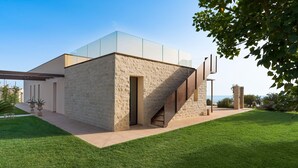 Ein modernes Gebäude mit Glasfassade im oberen Bereich und steinernen Wänden im unteren Bereich, mit einer sichtbaren Treppe.