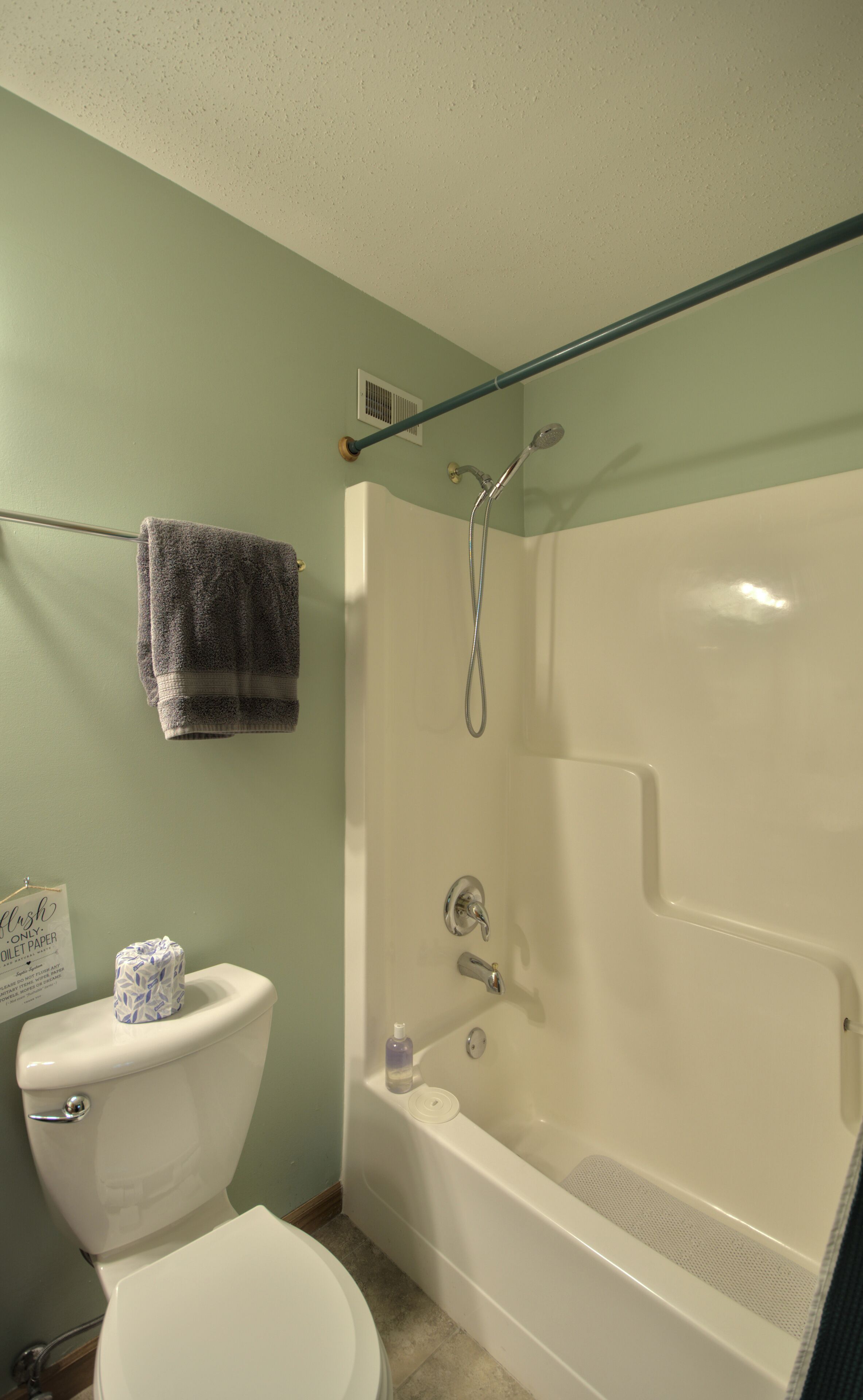 A bathroom with a toilet, a bathtub, and a shower.
