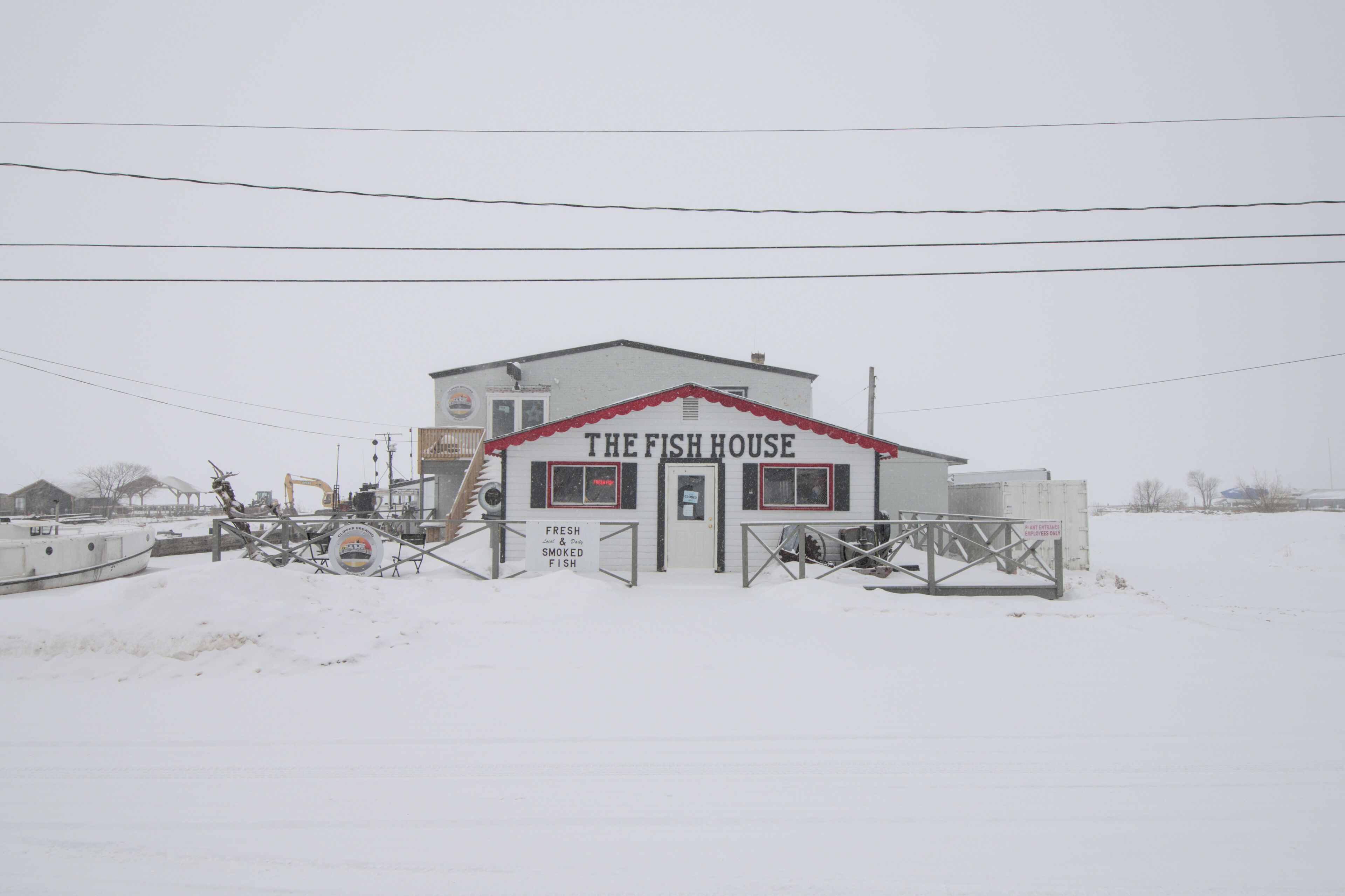A building labeled "The Fish House" with a sign indicating it sells fresh and smoked fish.