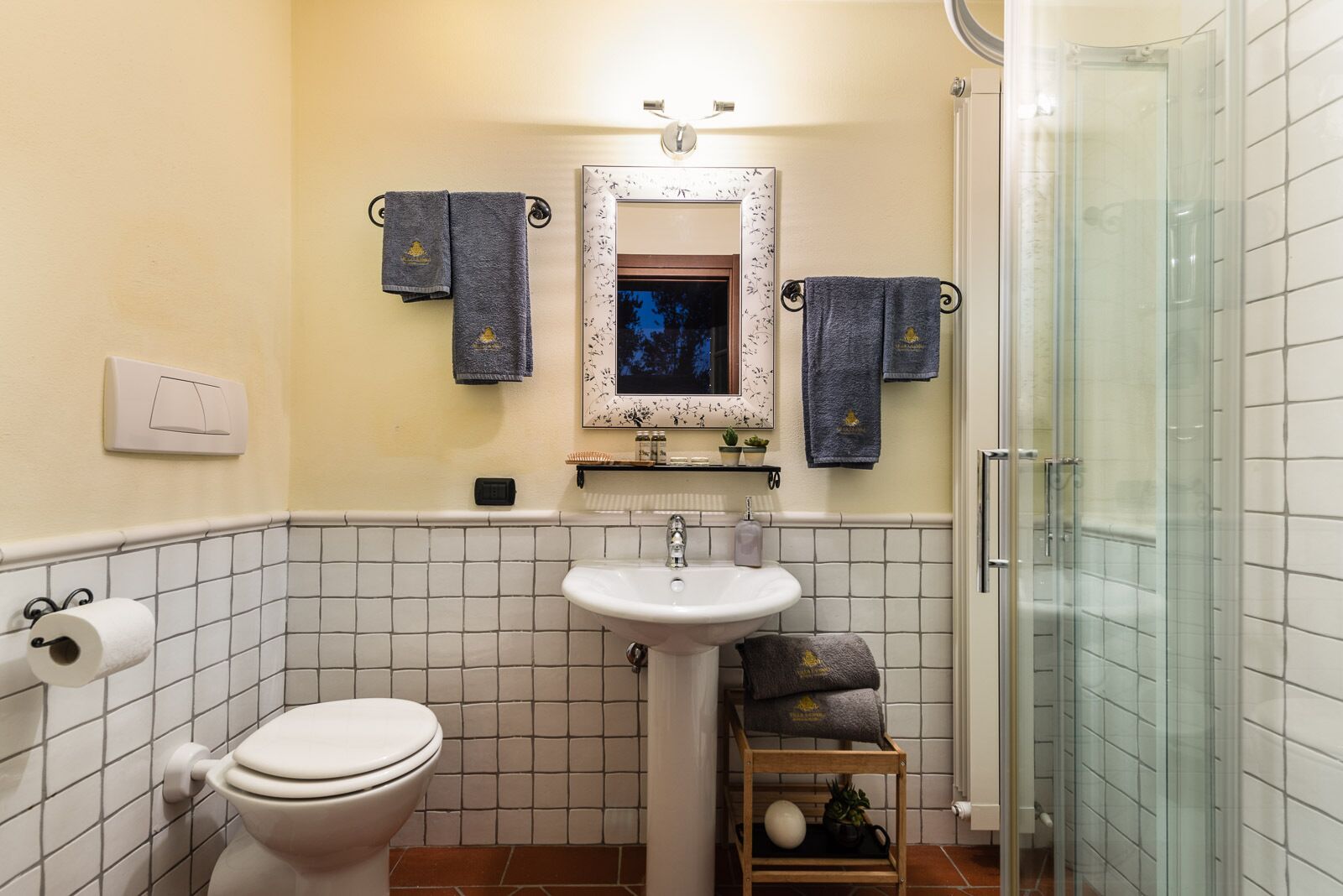 A bathroom with a toilet, sink, and shower.
