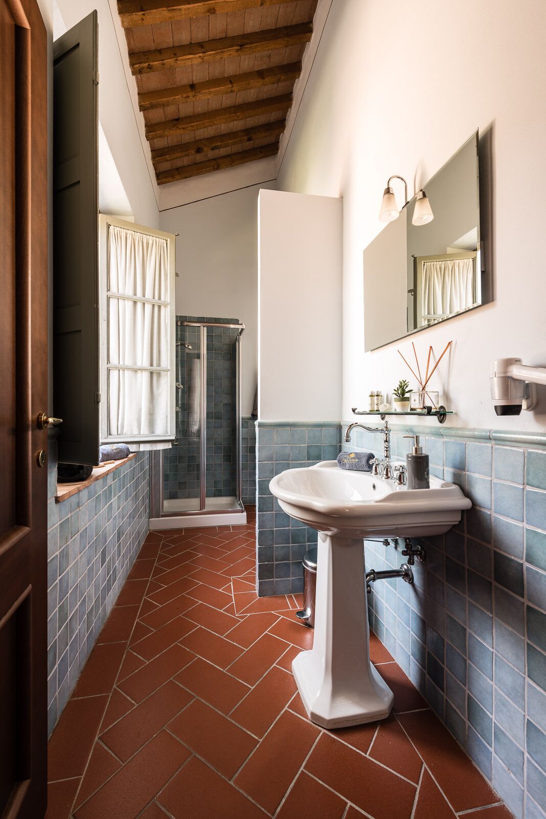 Un baño con ducha, lavabo y espejo.