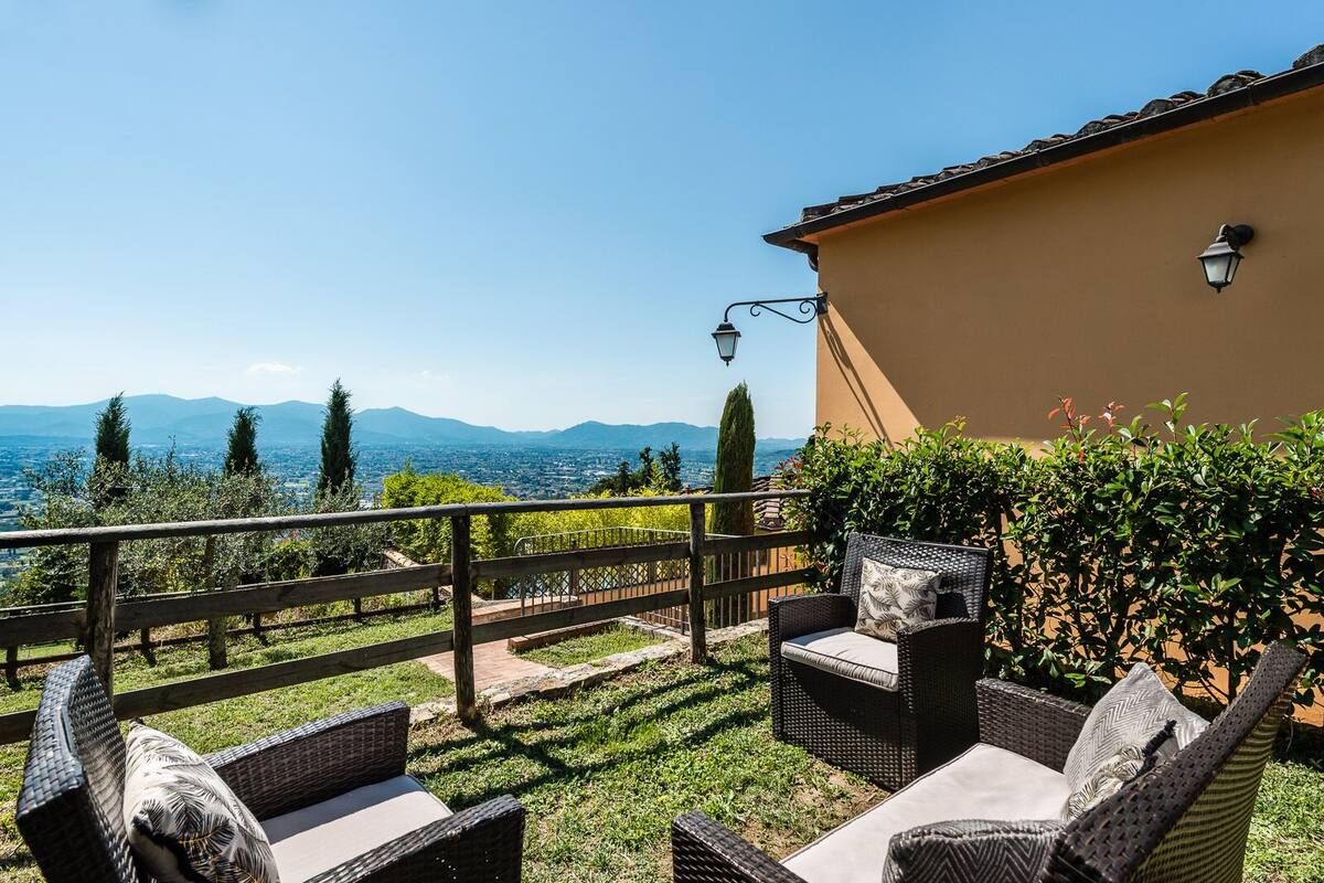 A patio with wicker furniture and a view of mountains.