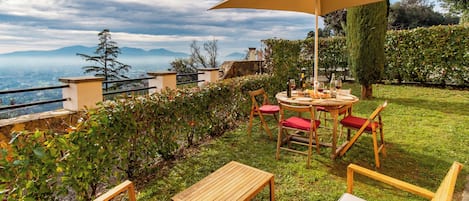 An outdoor patio with a table, chairs, and a large umbrella.