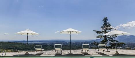 Een seizoensgebonden buitenzwembad en parasols bij het zwembad