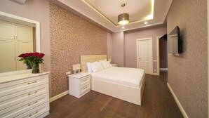 A bedroom with a bed, nightstands, a dresser, a mirror, and a TV. - Mount Ararat View 2-bedroom Luxury Apartment on 13 Buzand street by Sweet Home (Yerevan)