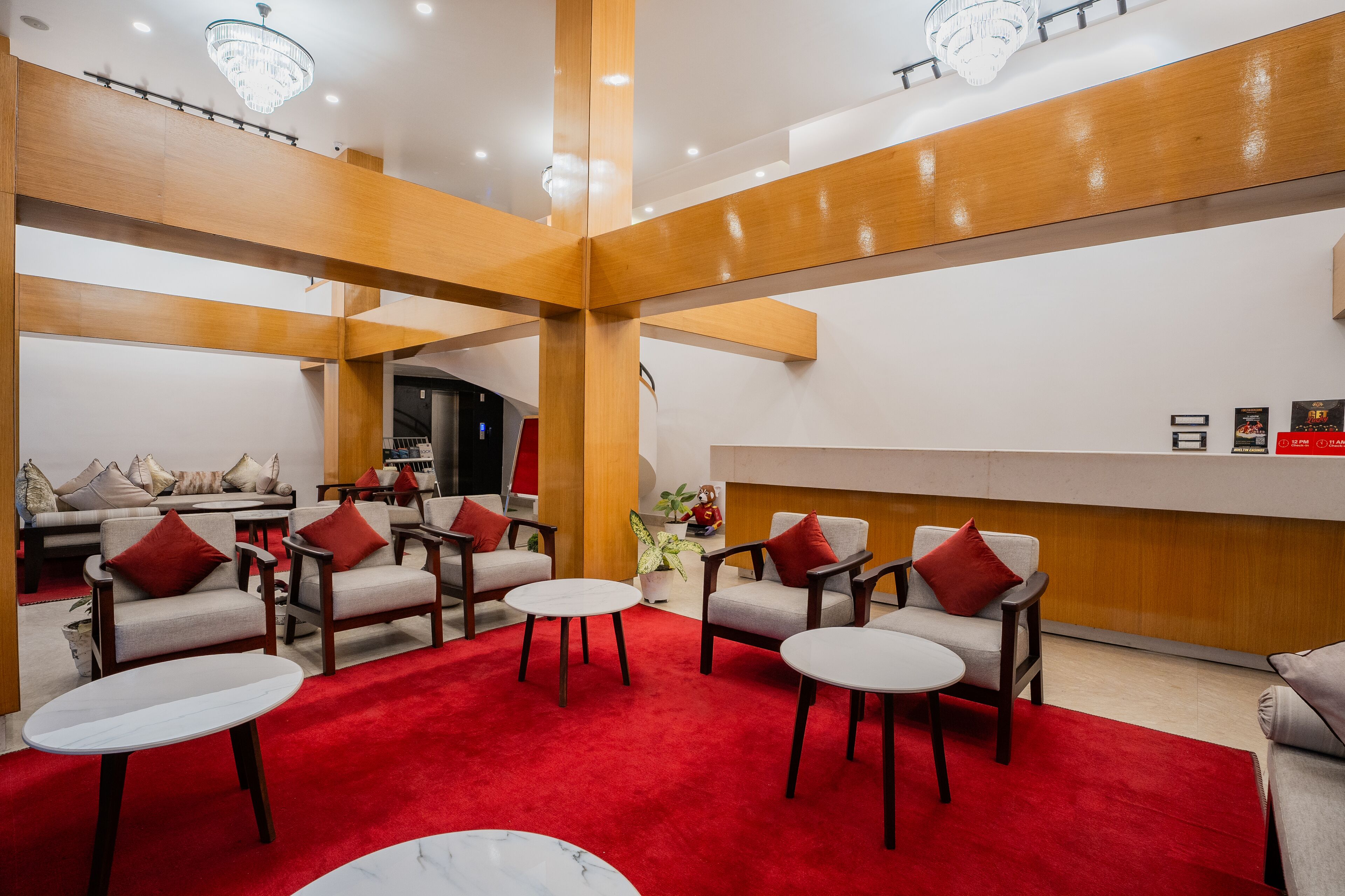 A lobby with a red carpet, wooden beams, and a reception desk.