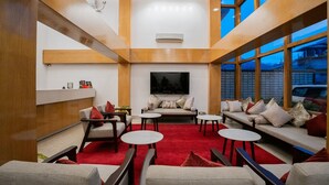 A modern interior with a red carpet, sofas, and a TV screen. - SUMMIT GRAND RESORT & SPA , GANGTOK  (Gangtok)